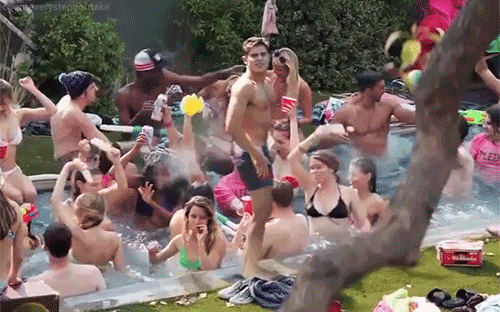 tons of people partying in a pool!.