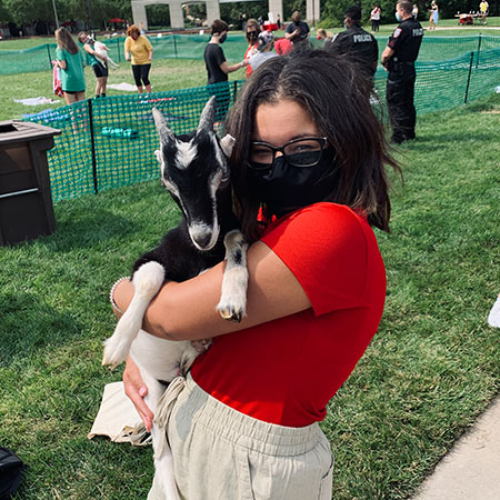 Sydney wearing a facemask and holding a goat