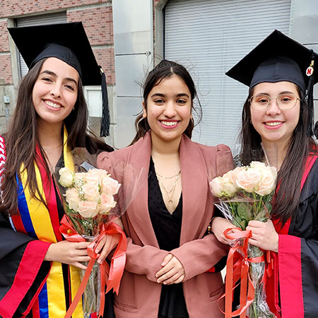 Nidhi with friends graduating holding flowers