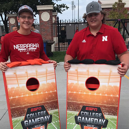 Bryar with friend holding ESPN College Gameday cornhole boxes